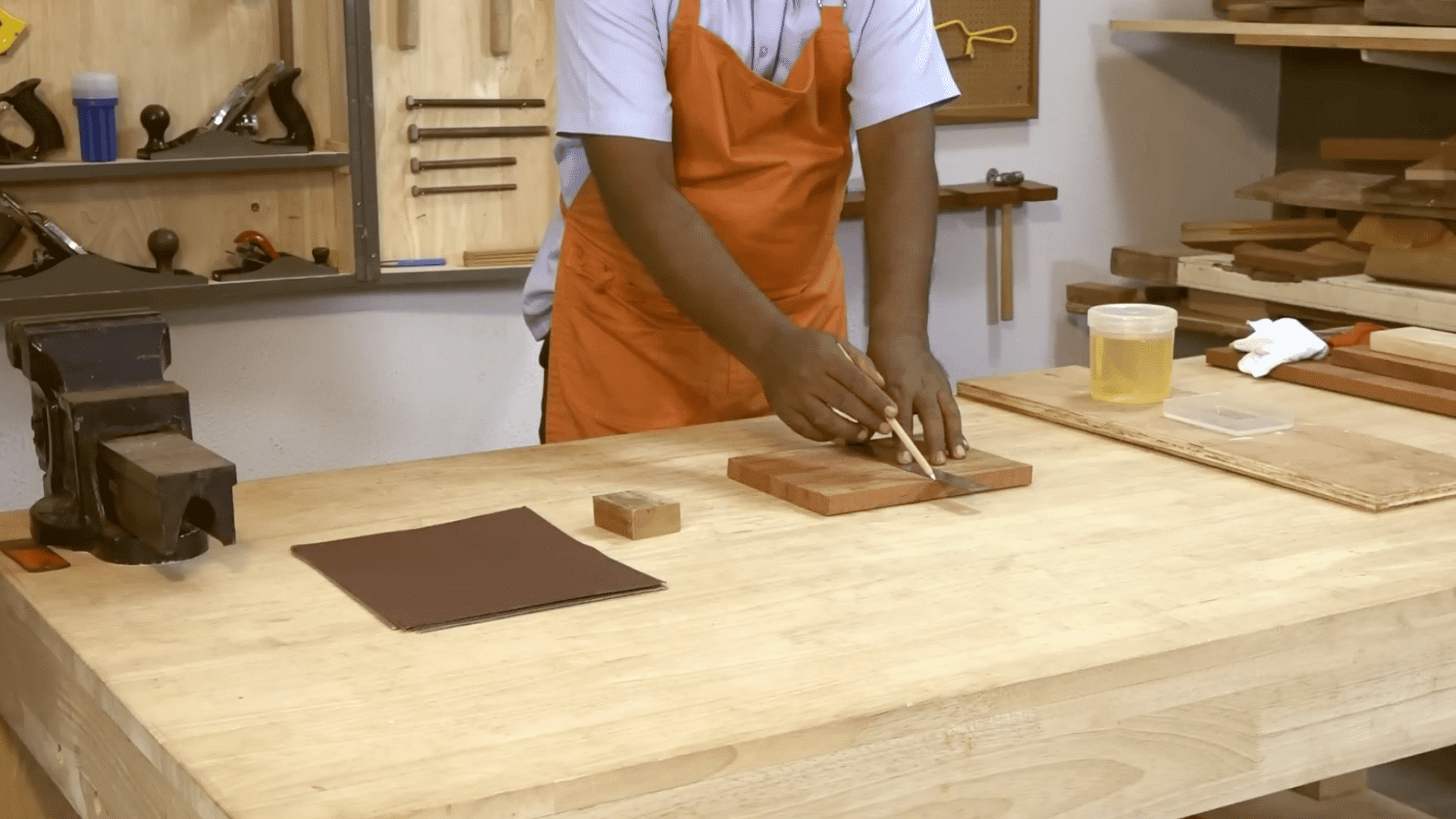 person in workshop applying polish to wooden board with brush demonstrating how to polish wood furniture step by step