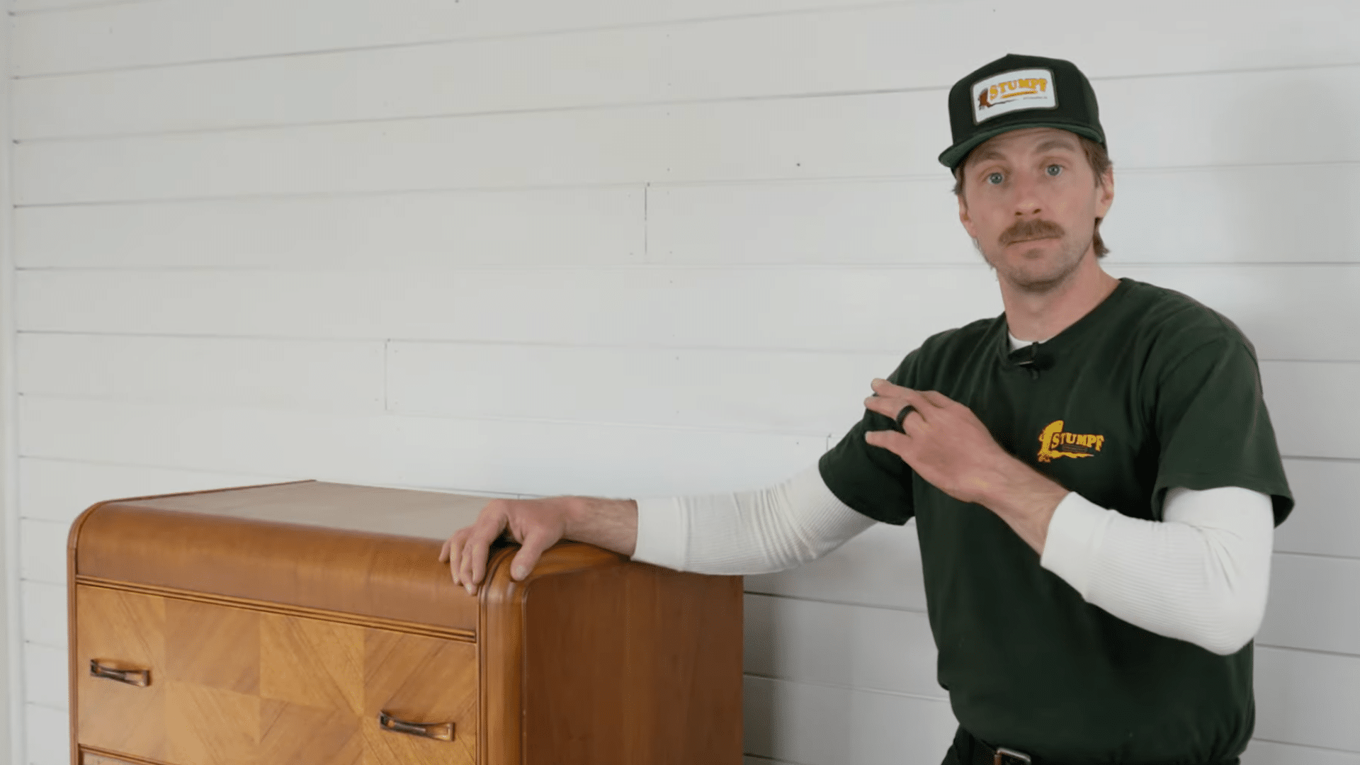 person standing beside a wooden dresser explaining the need to clear the path before moving furniture