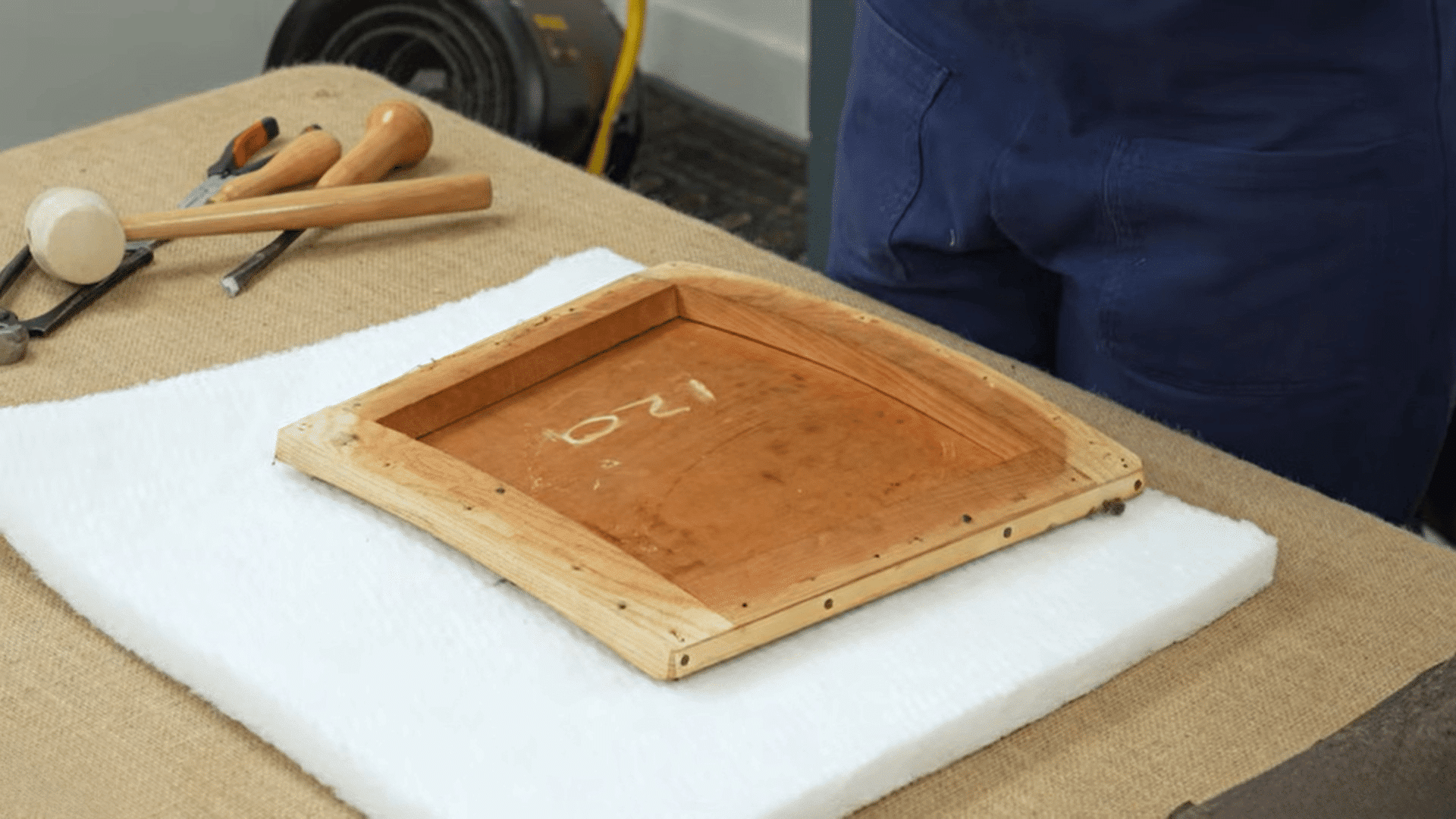foam padding and chair base prepared to reupholster dining chairs in workshop