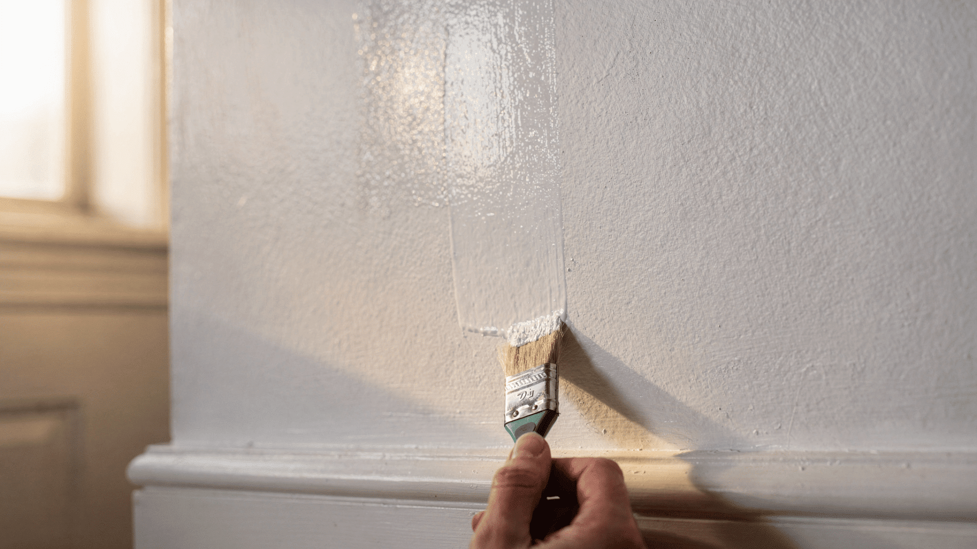 close up of semi gloss painted wall showing visible touch up patch that catches light differently from surrounding paint