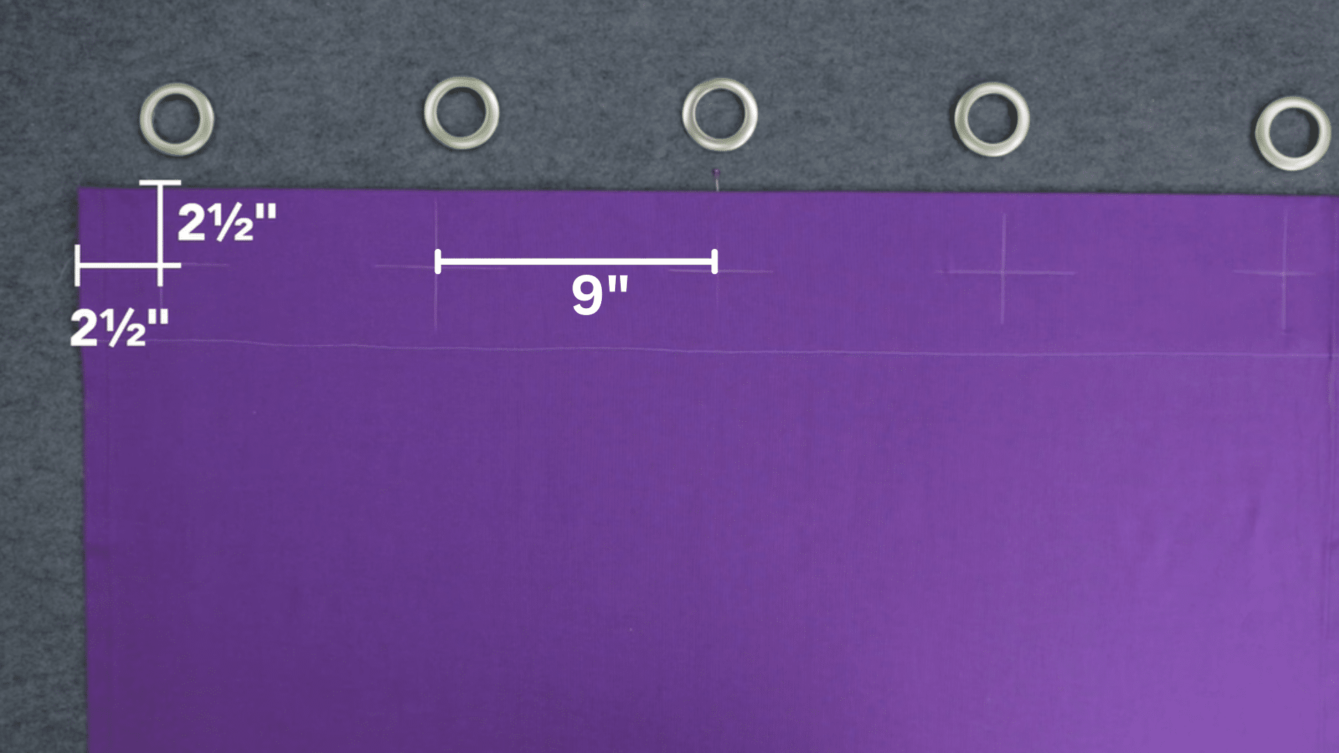 curtain fabric with marked spacing for grommets showing measured gaps and placement points along the top edge