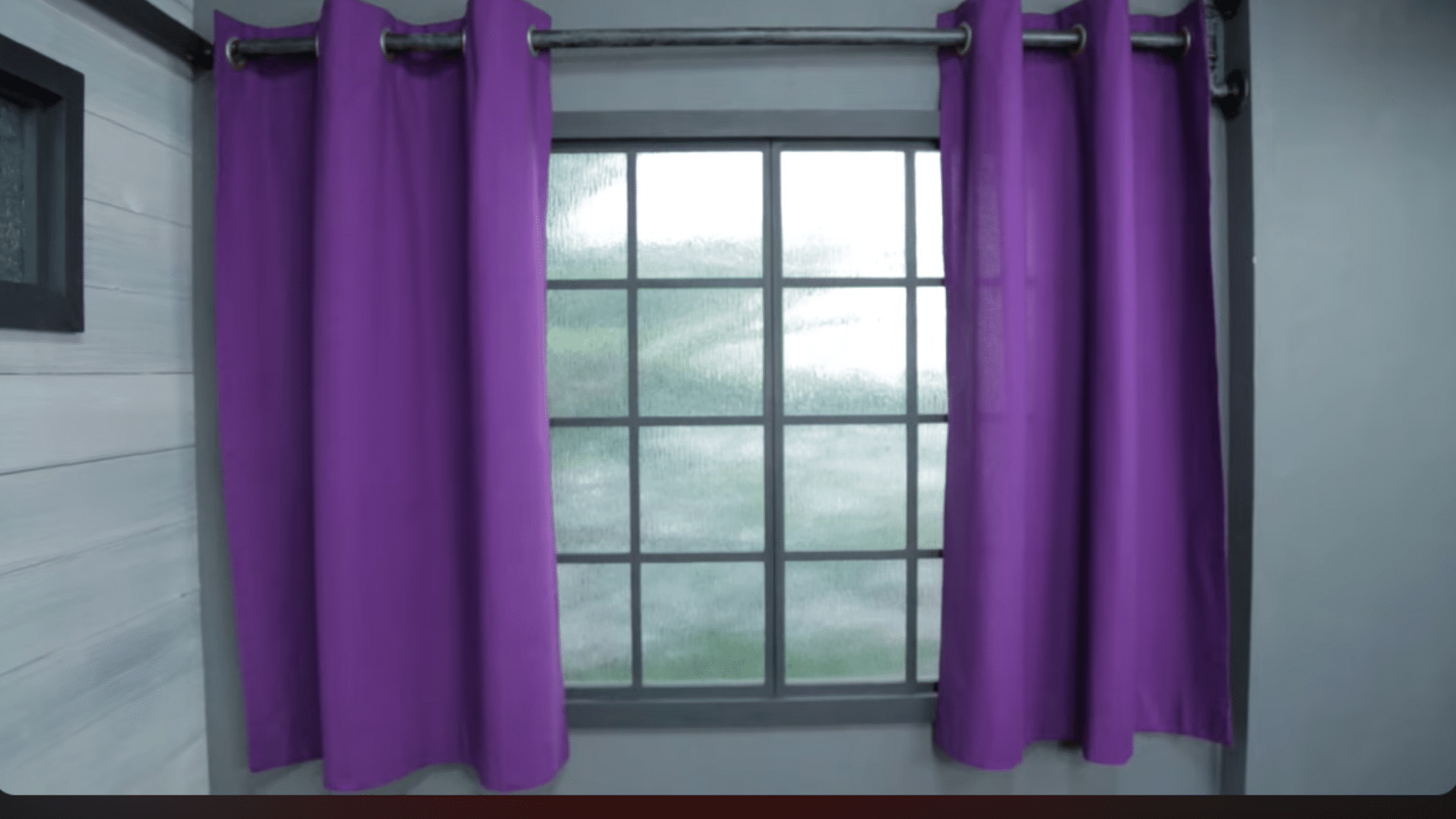 purple curtains hanging evenly on a rod through grommets showing neat folds and balanced spacing on both sides of the window (1)