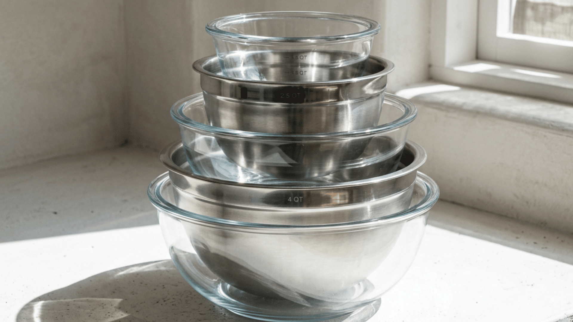 set of mixing bowls arranged on a clean white surface with soft natural light from a nearby window